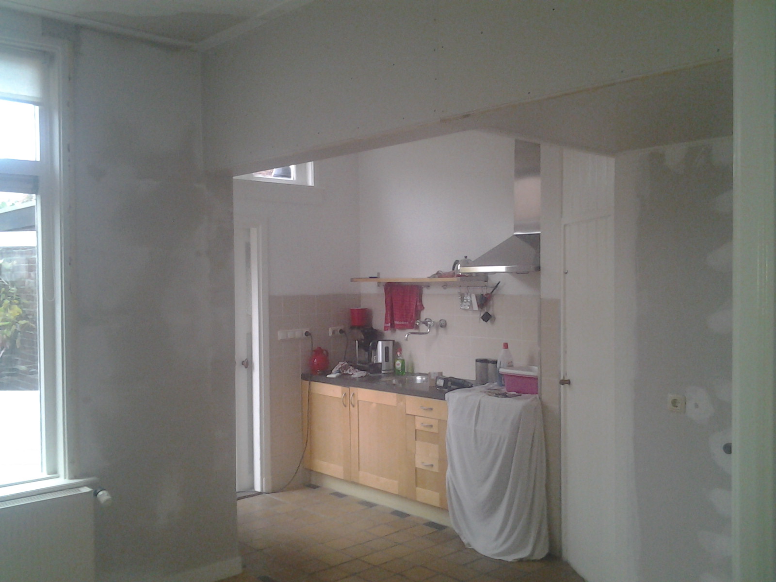 Verwijderen van een tussenmuur tussen de keuken en de woonkamer.